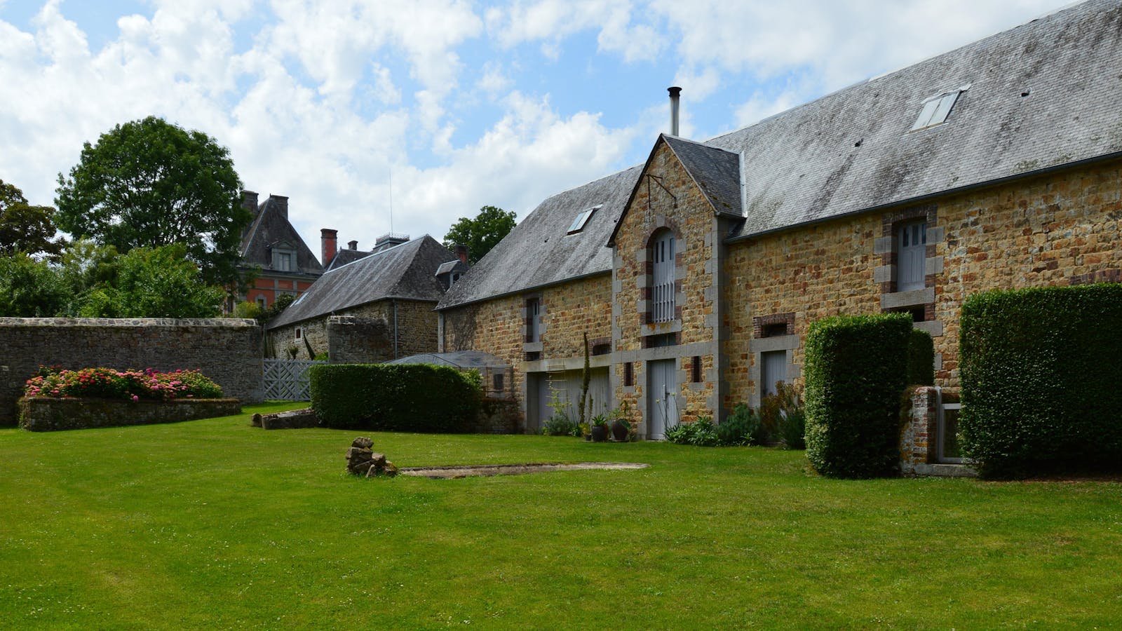 Traditional Normandy stone building with a lush garden near Giverny