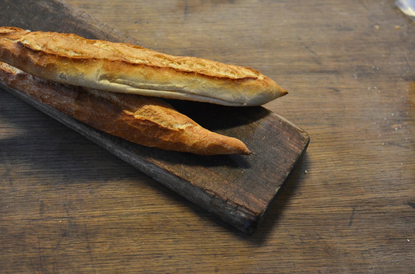 Golden-crust French baguette on a rustic wooden cutting board
