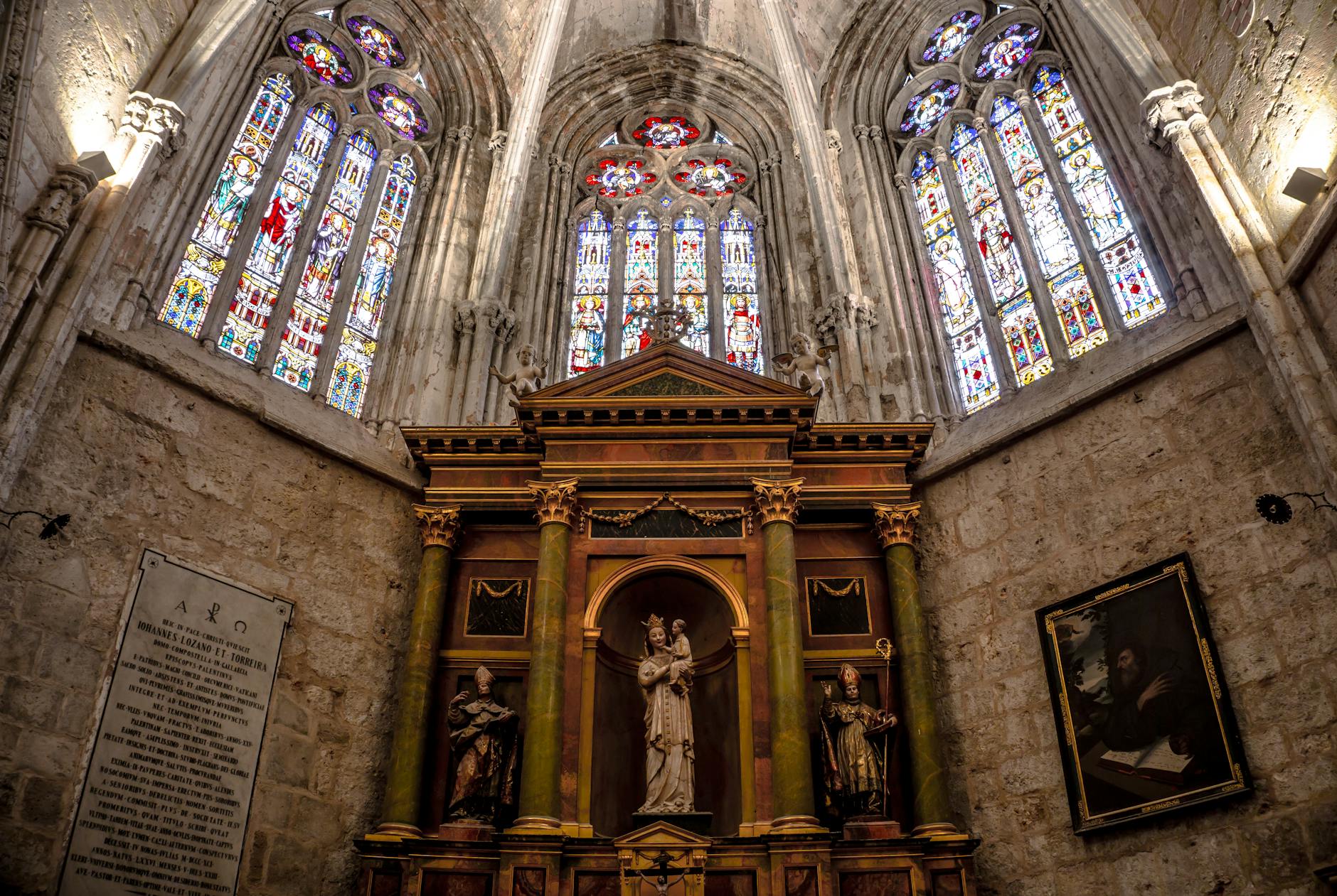 Gothic altar framed by ornate stained glass windows