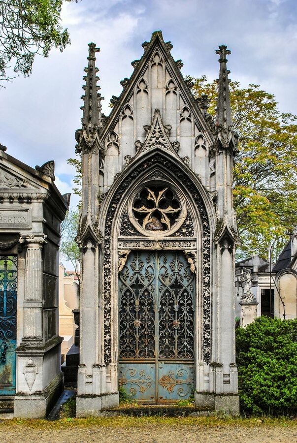 Gothic stone mausoleum in Pere Lachaise Cemetery Paris with ornate architecture