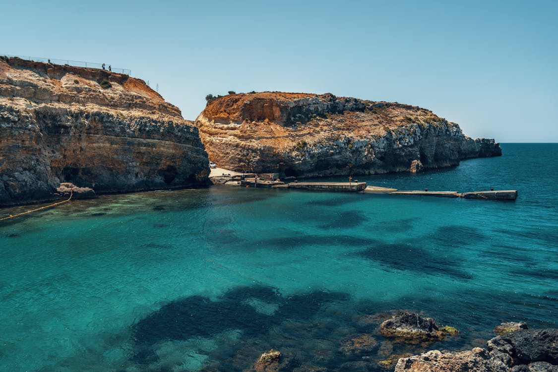 Gozo coastal cliffs with crystal clear blue waters