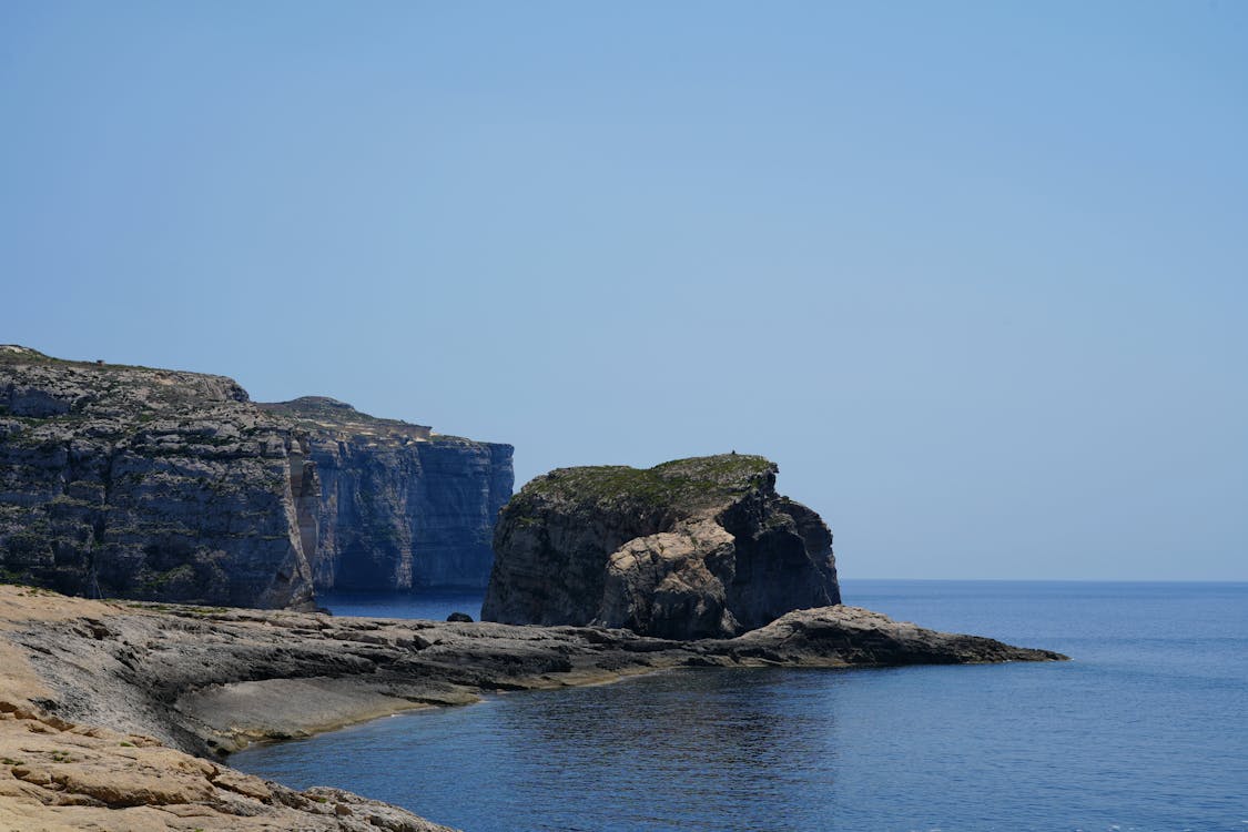 Dramatic coastal cliffs with clear blue sea in Gozo Malta