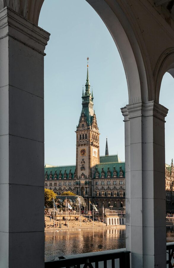 Hamburg City Hall framed by arches along the Alster