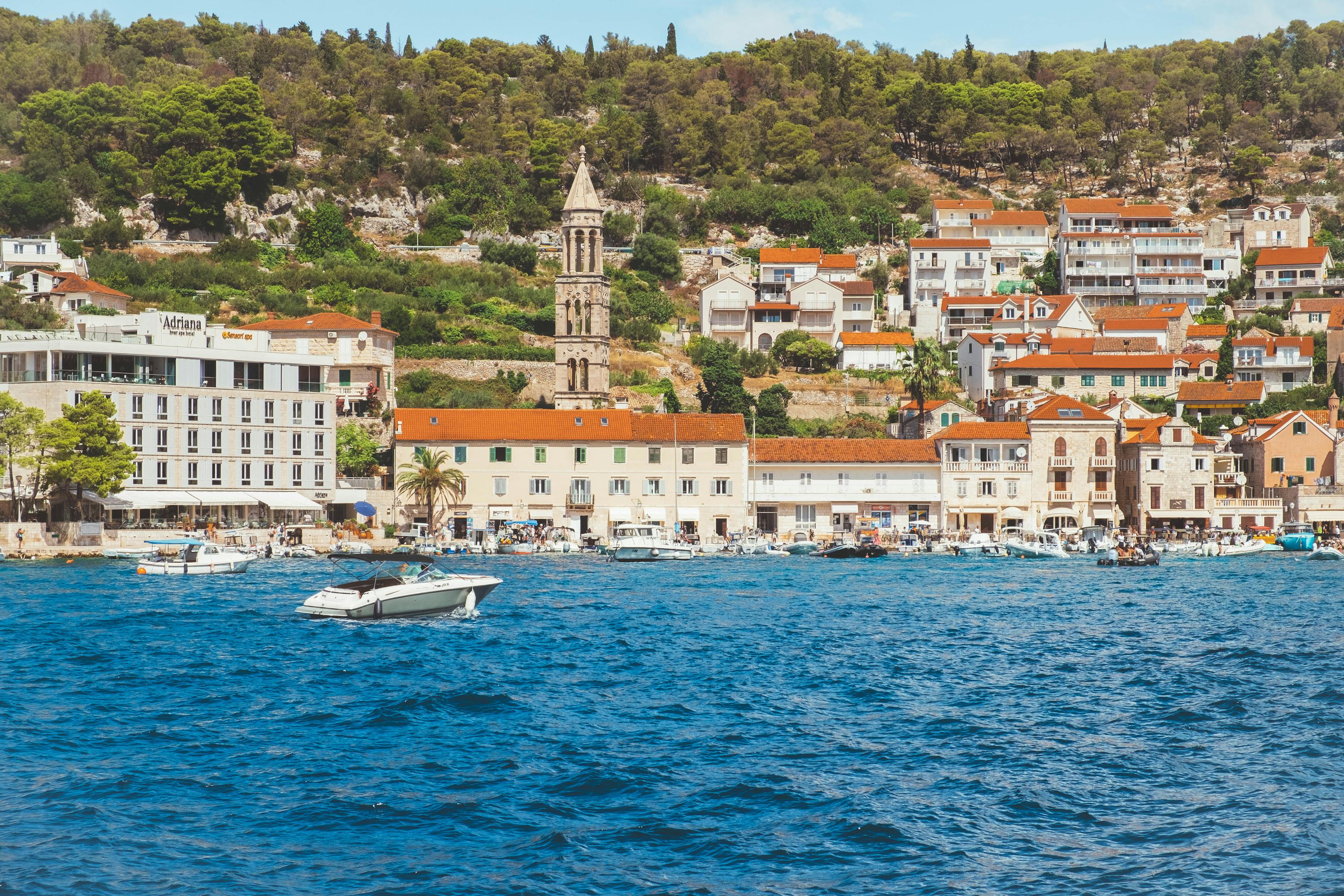 Beautiful harbor in Hvar with boats, historic buildings, and palm trees — a charming travel destination