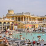 The outdoor pools at Széchenyi Thermal Bath in Budapest with yellow neo-baroque building in background