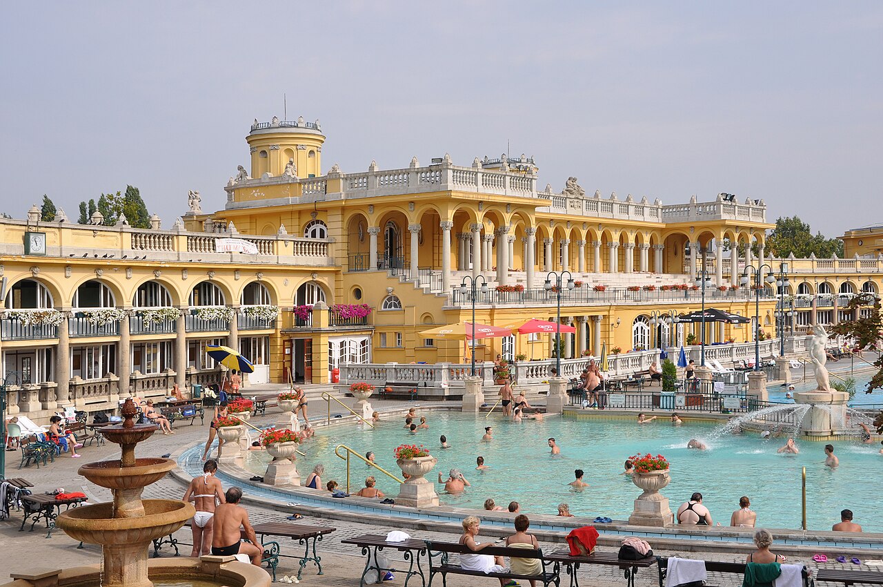 The outdoor pools at Széchenyi Thermal Bath in Budapest with yellow neo-baroque building in background