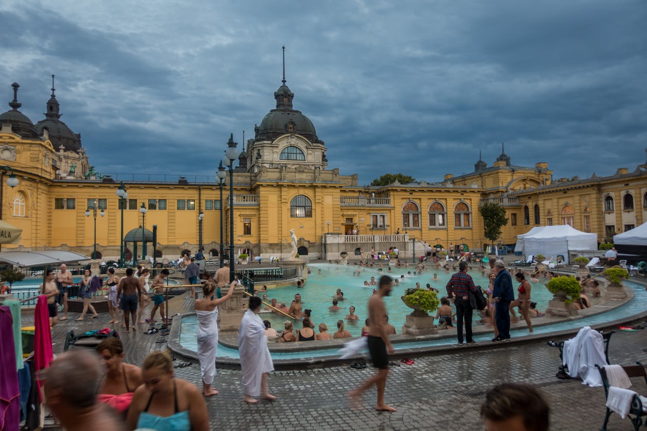 People relaxing in the warm thermal pools at Széchenyi Bath with historic architecture