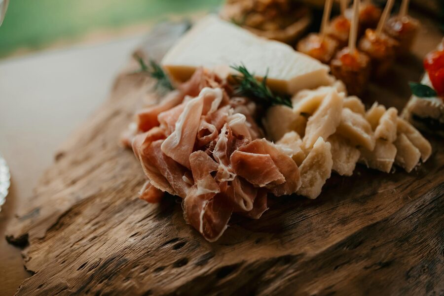 Italian cheese and prosciutto platter on rustic wooden board