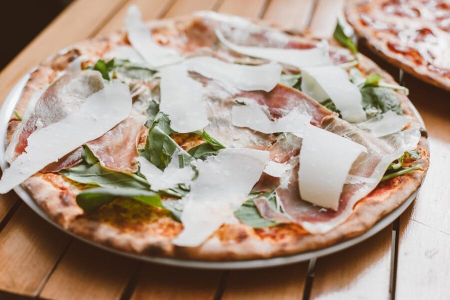 Italian pizza with prosciutto and arugula on wooden board