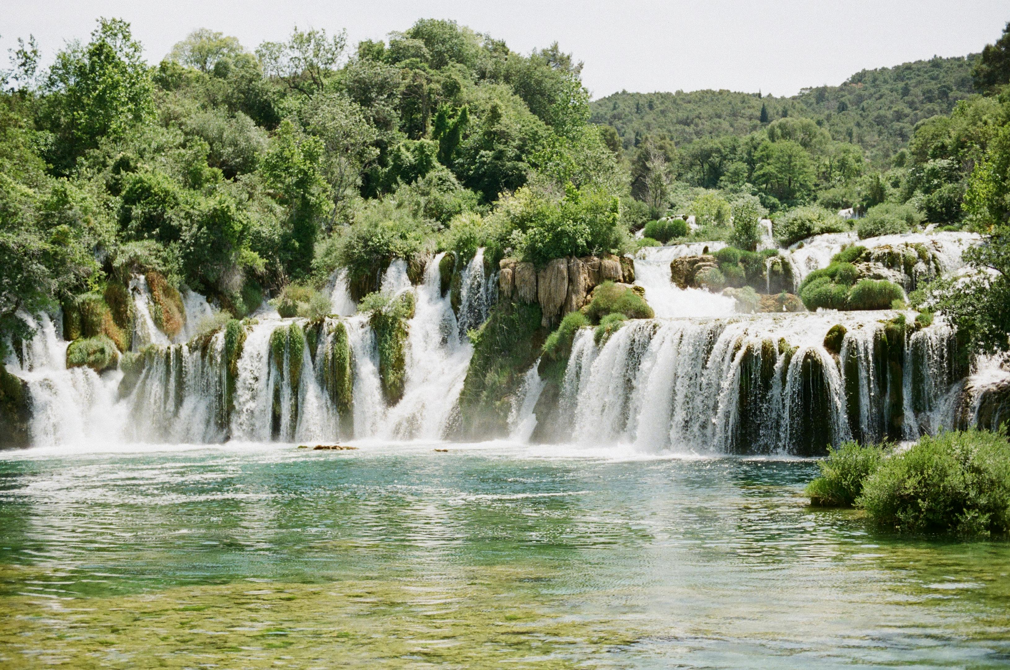 Serene waterfall amidst dense forest, perfect nature getaway