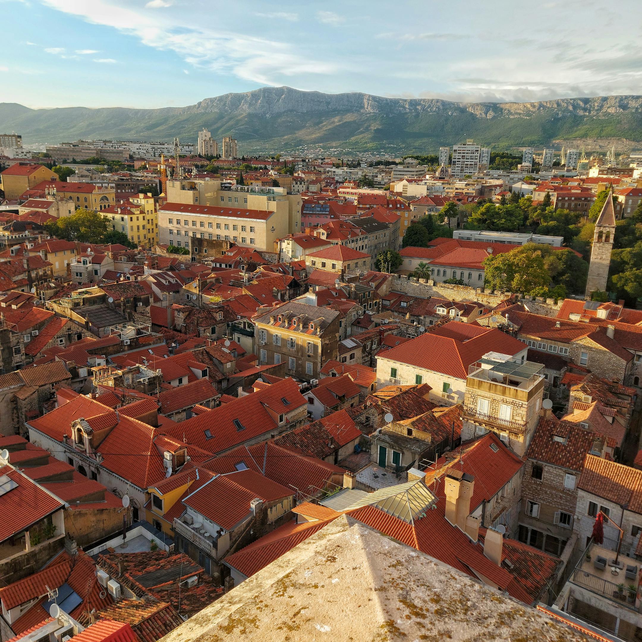 Discover the vibrant red rooftops of Split, Croatia, set against a mountainous backdrop