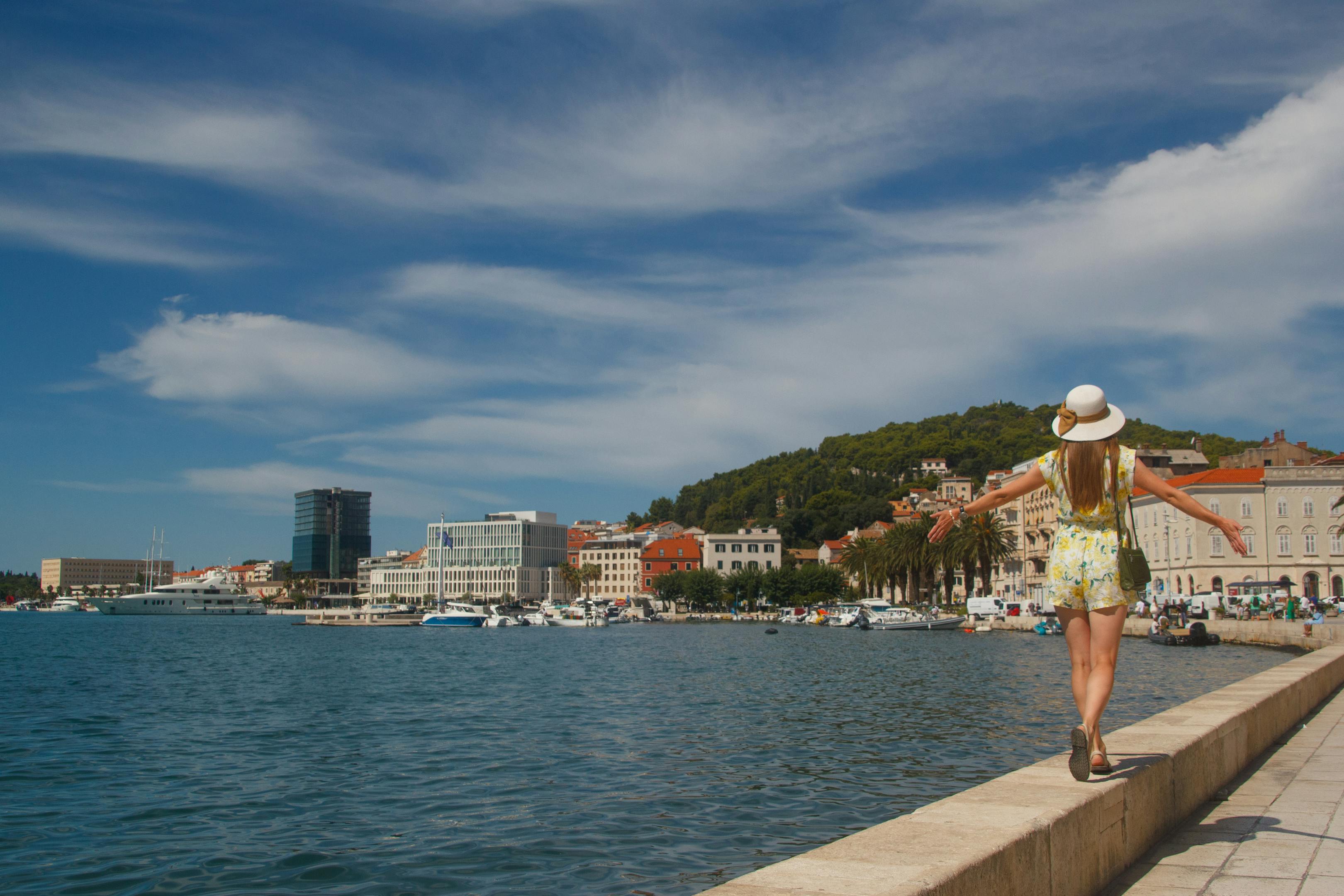 A tourist walks along the scenic waterfront promenade in Split