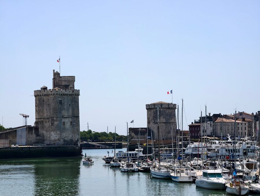 La Rochelle harbor with historic towers and boats under clear sky