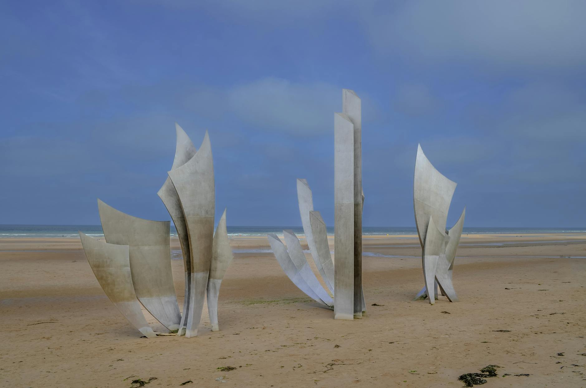 Les Braves sculpture on Omaha Beach Normandy with stainless steel wings rising from the sand