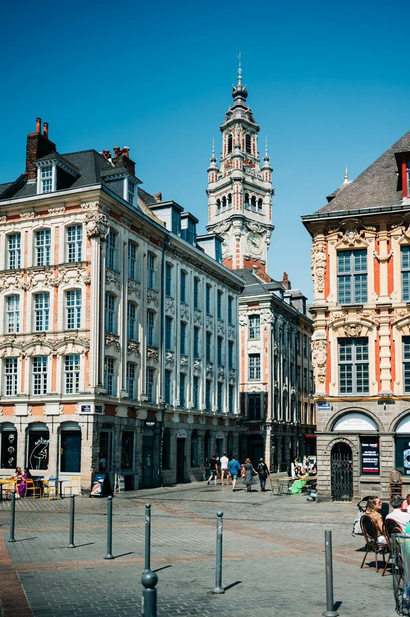 Historic square and tower in Lille under blue sky