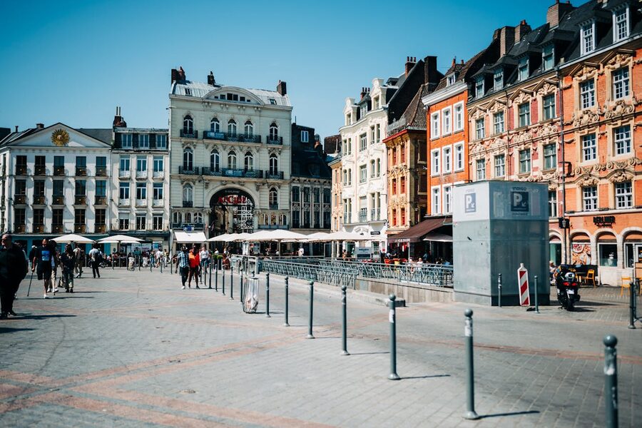 Street view of Place du General-de-Gaulle in Lille with colourful townhouses and pedestrians