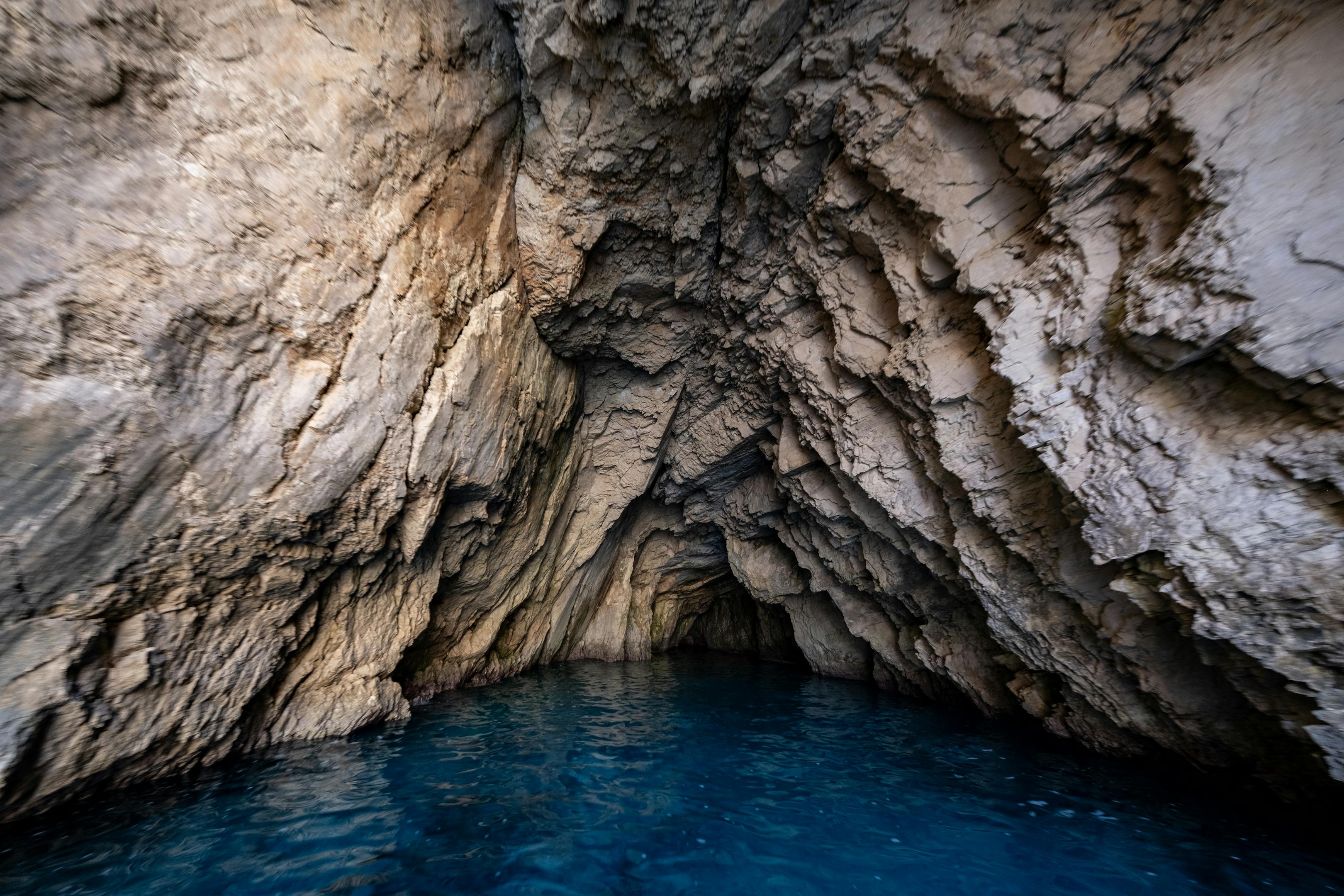 Explore a dramatic limestone cave with stunning blue water, capturing natural beauty and geological features