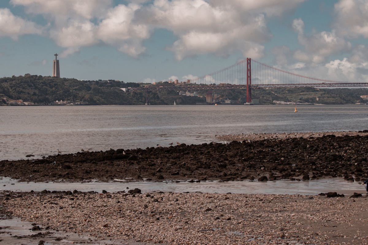 Wide view of the 25 de Abril Bridge with Cristo Rei statue in Lisbon