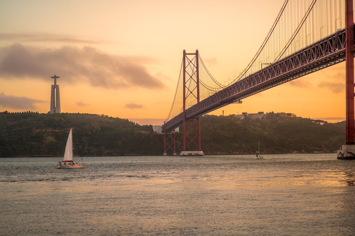 Sailboat on the Tagus River at sunset near the 25 de Abril Bridge