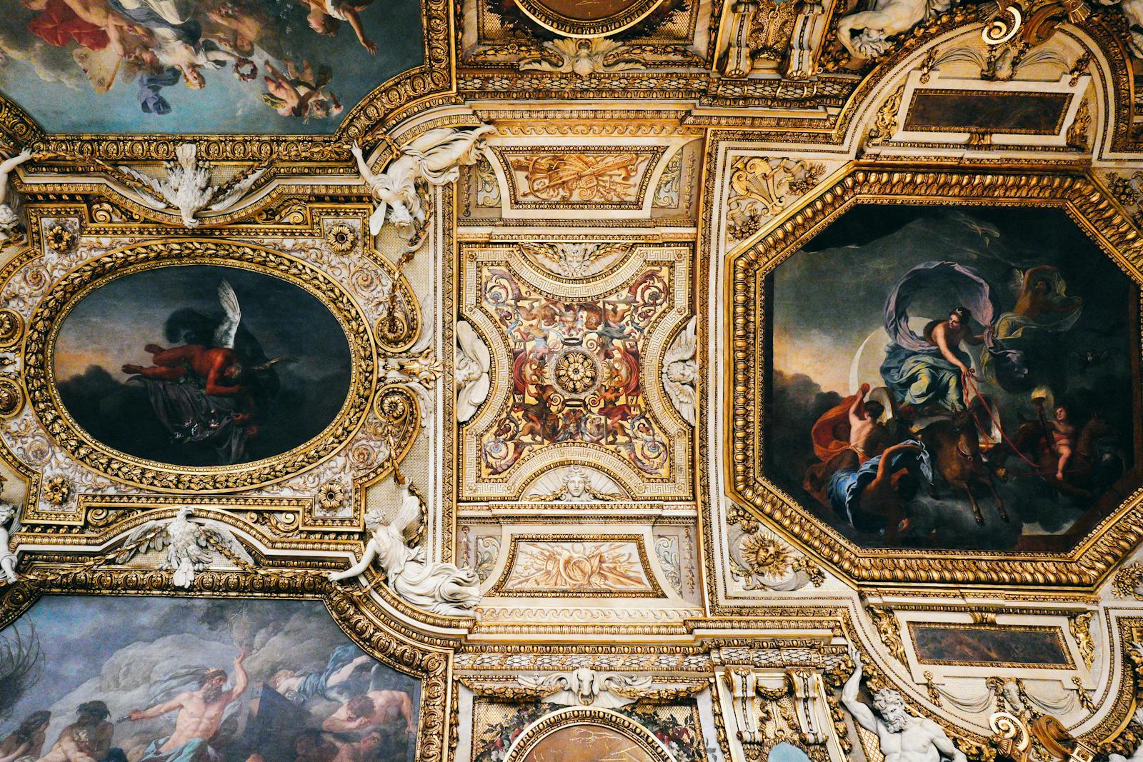 Detailed view of baroque ceiling art at the Louvre Museum
