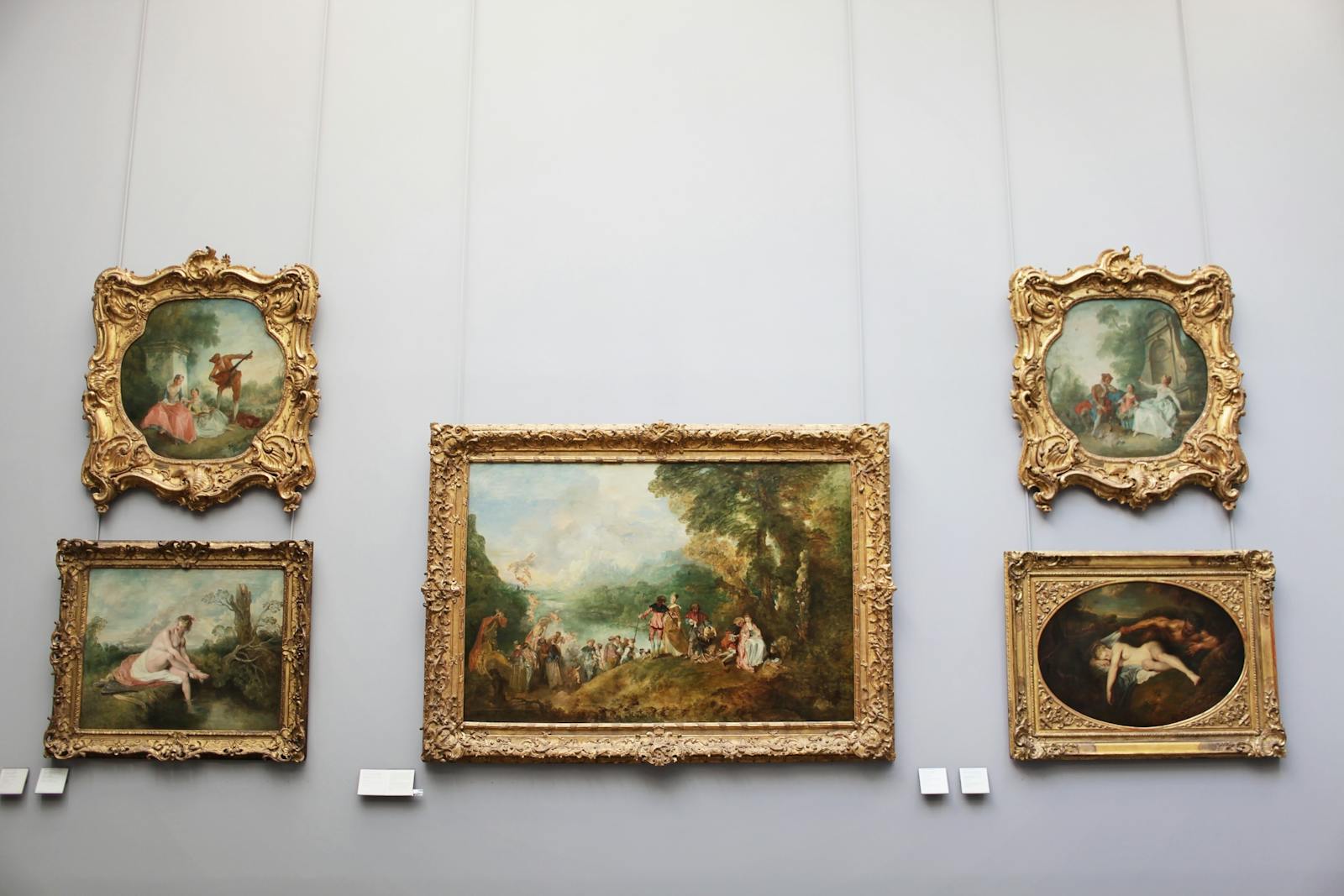 Collection of baroque paintings displayed in a Paris museum with gold frames