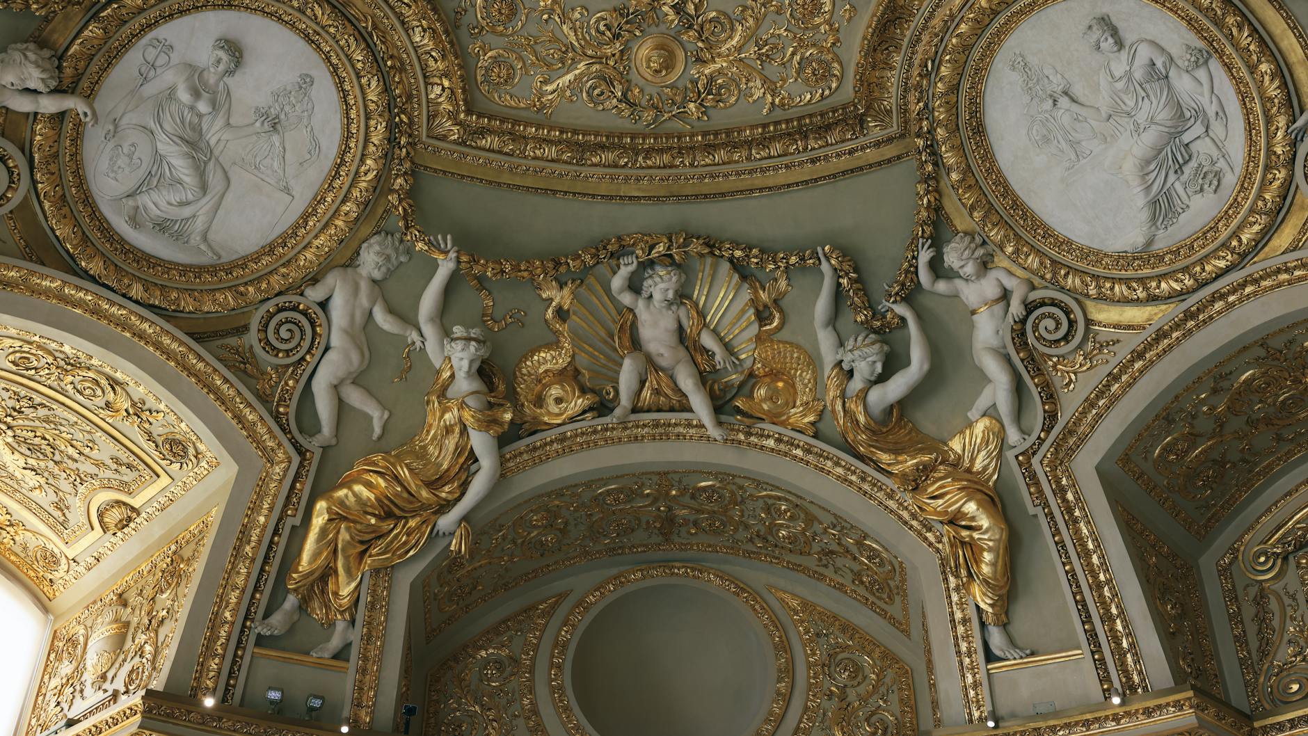 A detailed gilded ceiling inside the Louvre in Paris