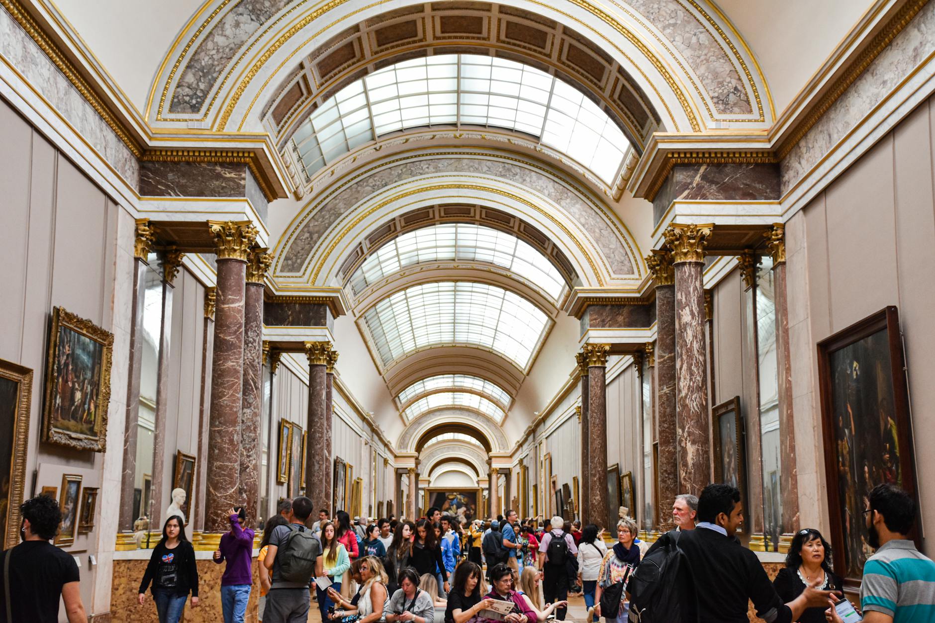 Tourists in the elegant interior of the Louvre with a large crowd