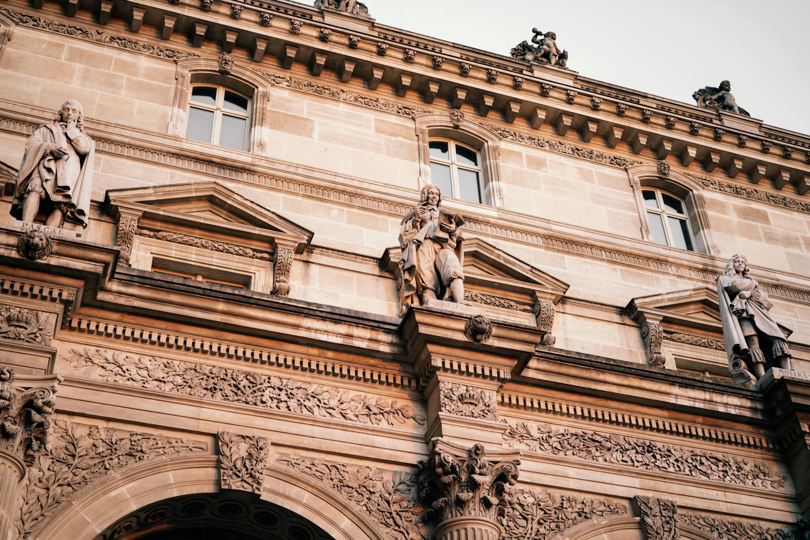 Facade of the Louvre Museum in Paris featuring intricate sculptures