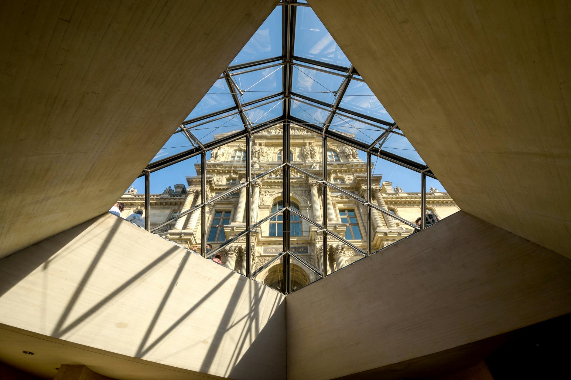 The Louvre Museum seen through the glass of the pyramid
