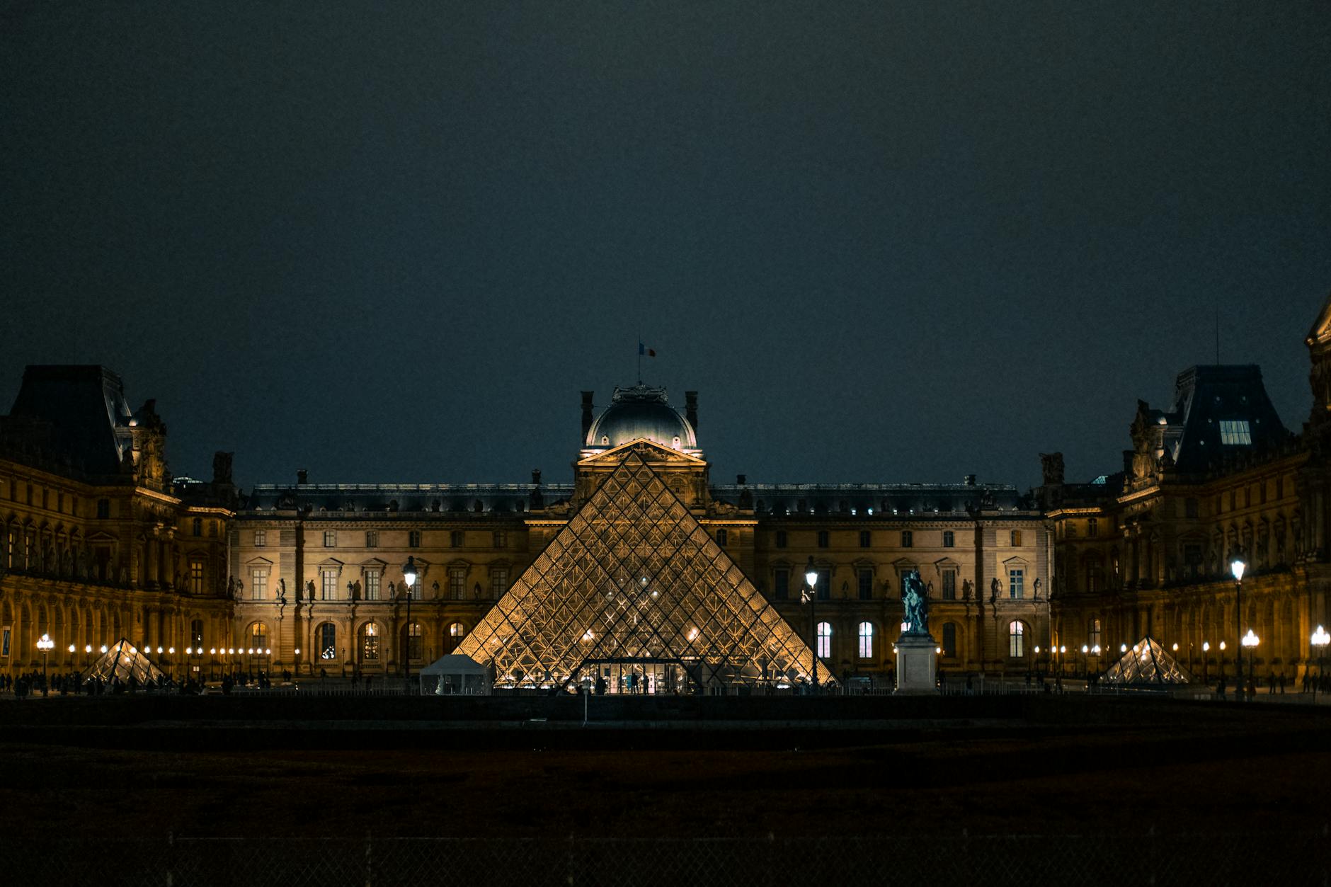 The Louvre Pyramid glowing against the Paris night sky