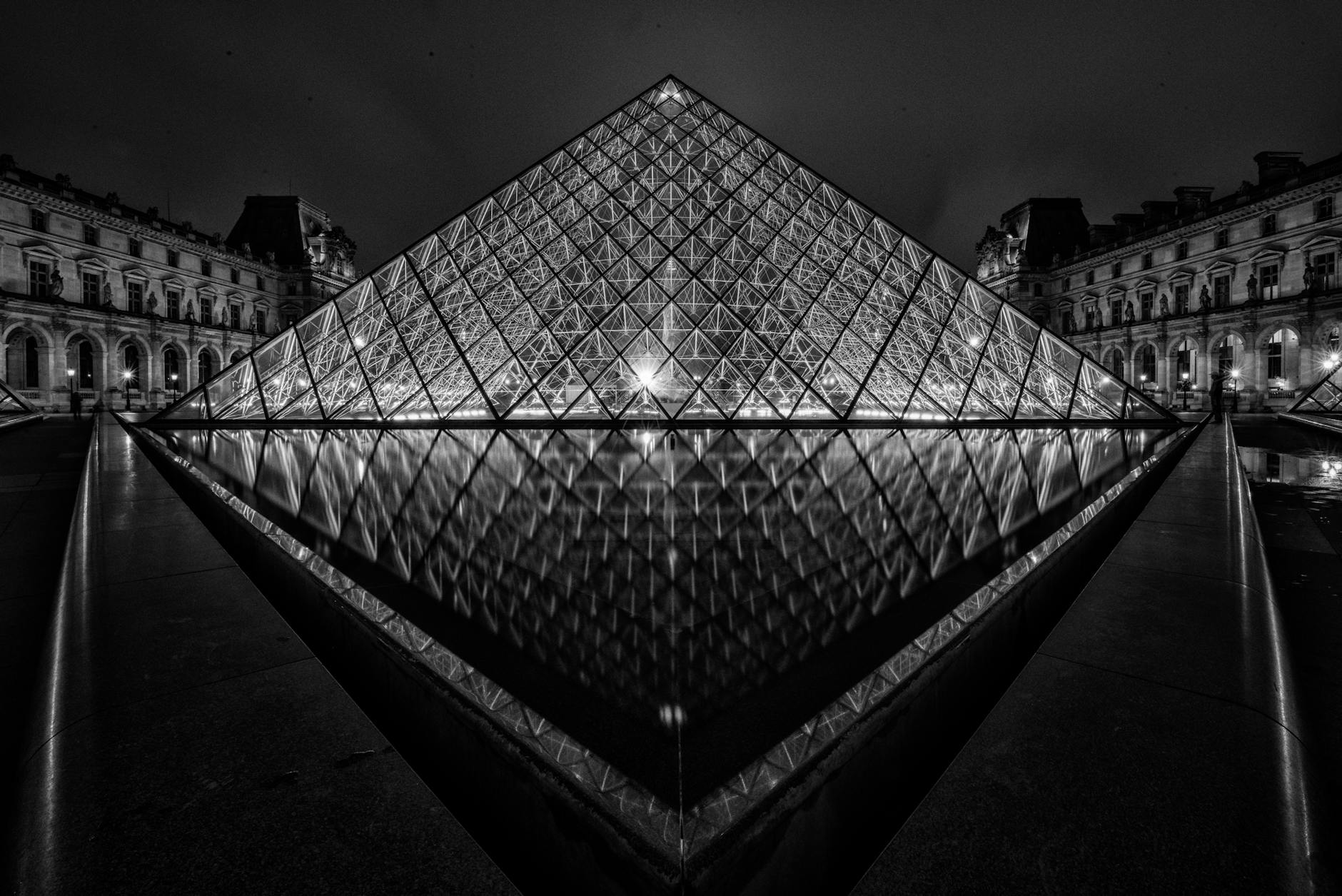 The illuminated Louvre Pyramid at night in black and white