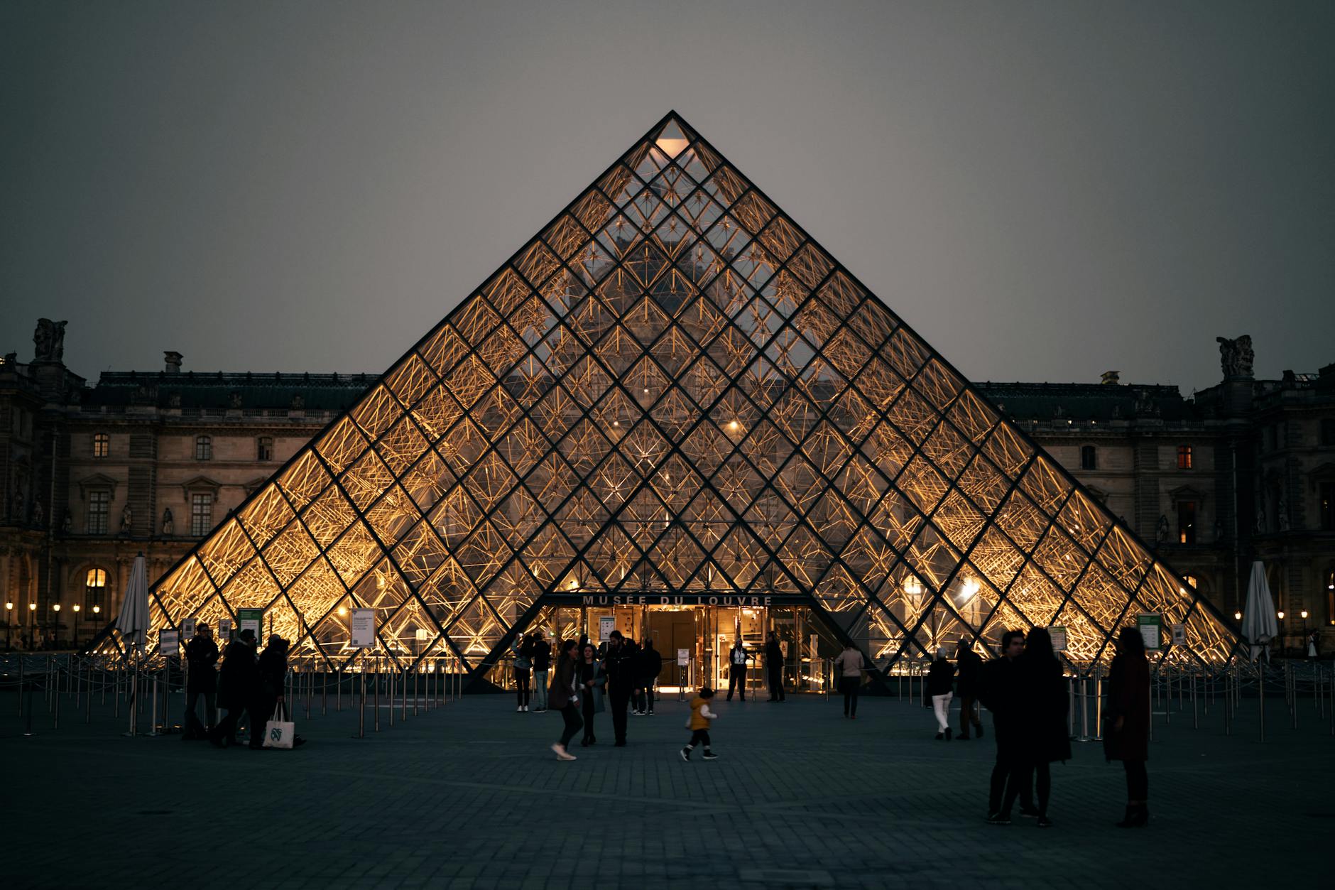 The Louvre Pyramid lit up at twilight in Paris