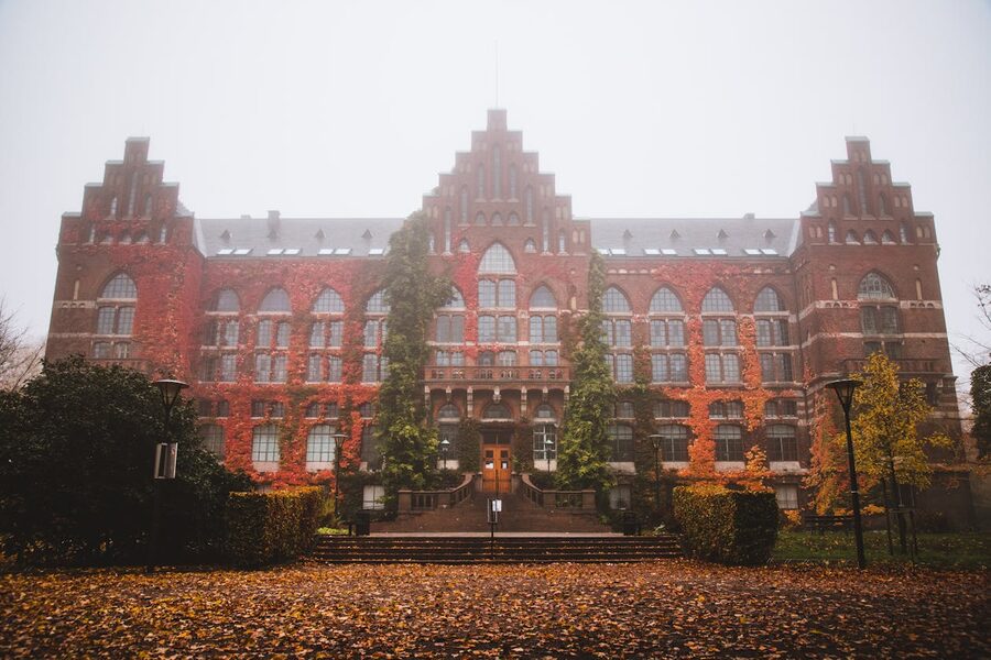 Historic Lund University Library facade with autumn foliage and fog in Lund Sweden