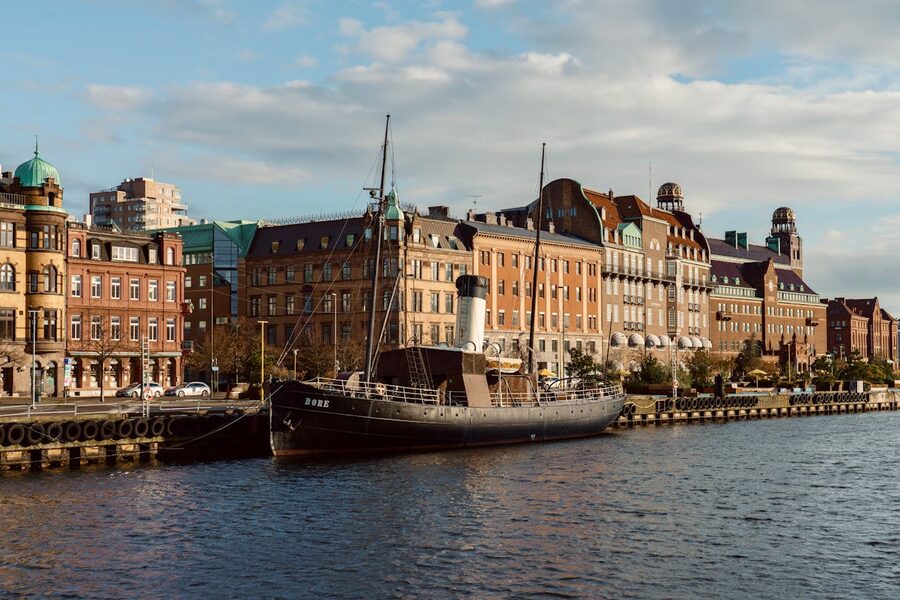 Historic steamship docked along waterfront with picturesque buildings in Malmö Sweden