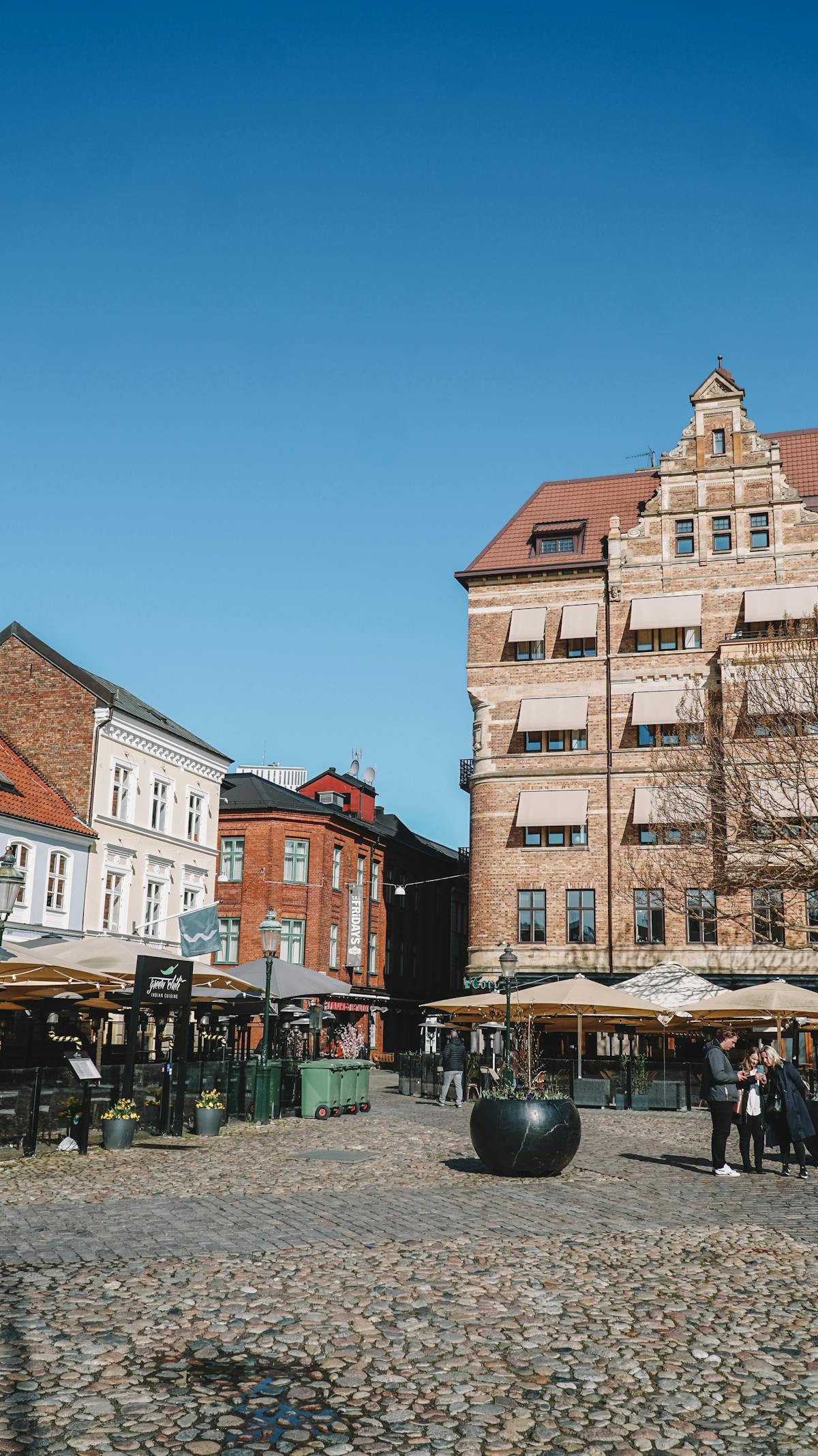Traditional buildings of Lilla Torg square in Malmö, Sweden under blue sky