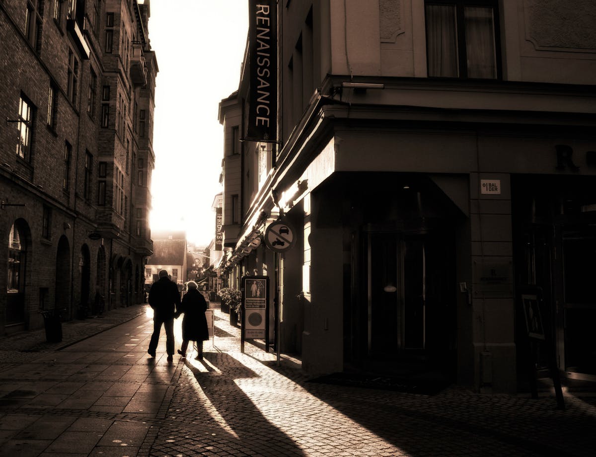 Couple walking along a historic street in Malmö at sunset