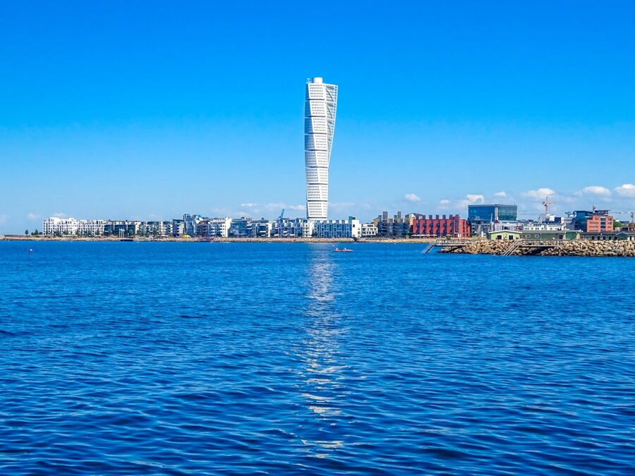 Iconic Turning Torso skyscraper standing above the Malmö coastline under a clear blue sky