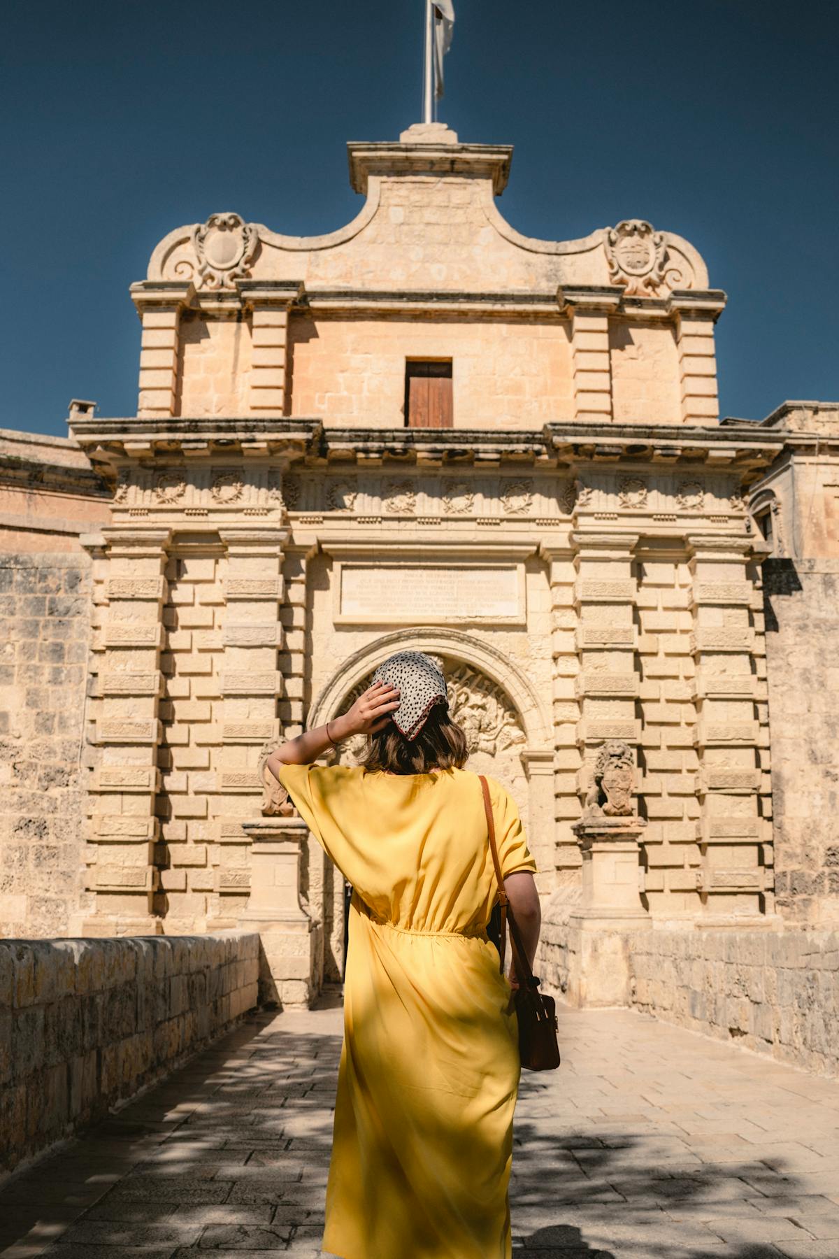 Visitor approaching the historic Mdina Gate entrance in Malta