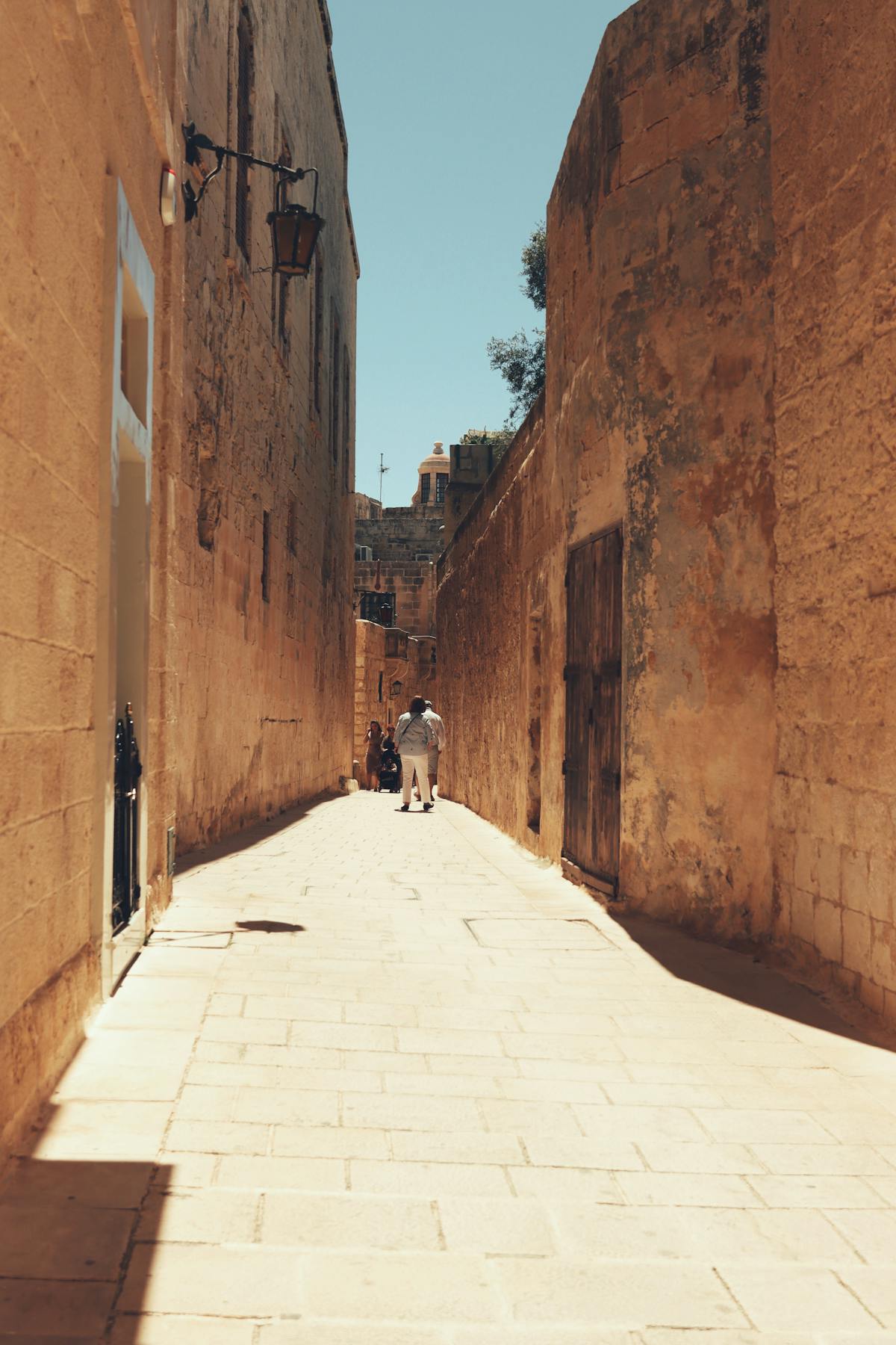 Sunlit narrow alley in the historic walled city of Mdina, Malta