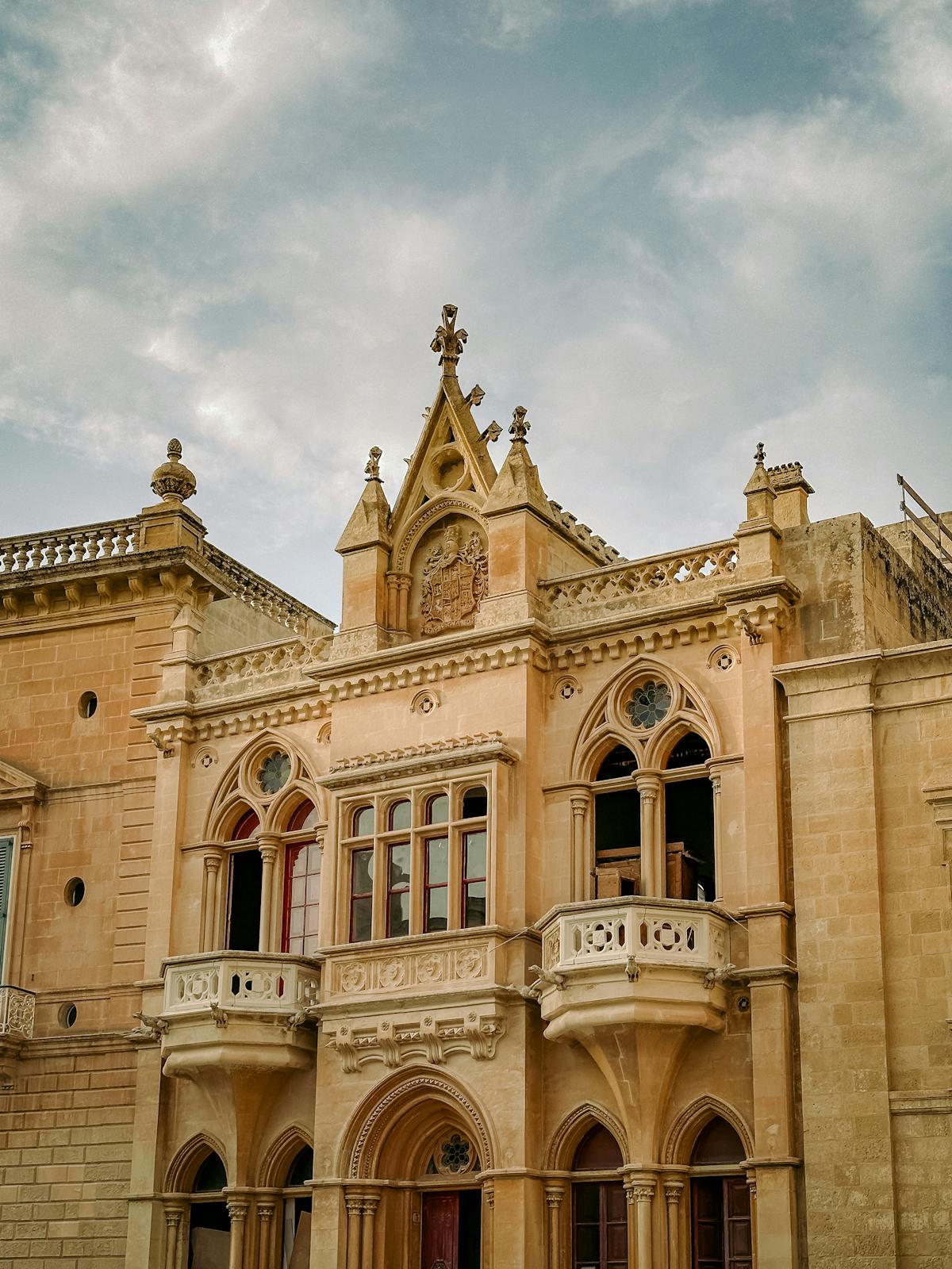 Palazzo Falson with Gothic architecture under a cloudy sky in Mdina, Malta