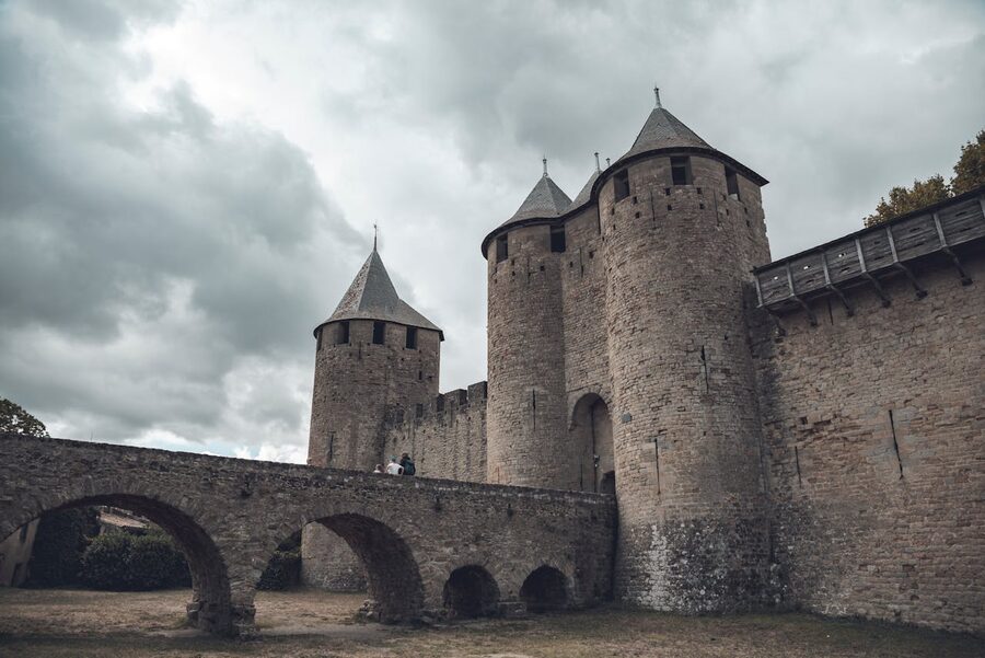 Medieval castle with towers and bridge under cloudy sky