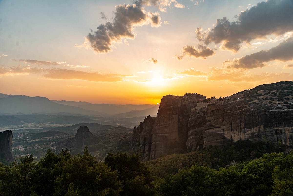 Dramatic sunset illuminating Meteora's iconic cliffs