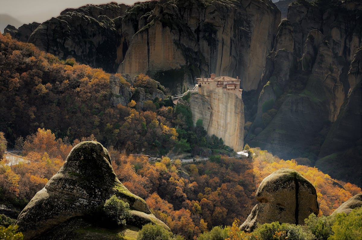 Meteora Monastery perched on rocky cliffs amid autumn foliage