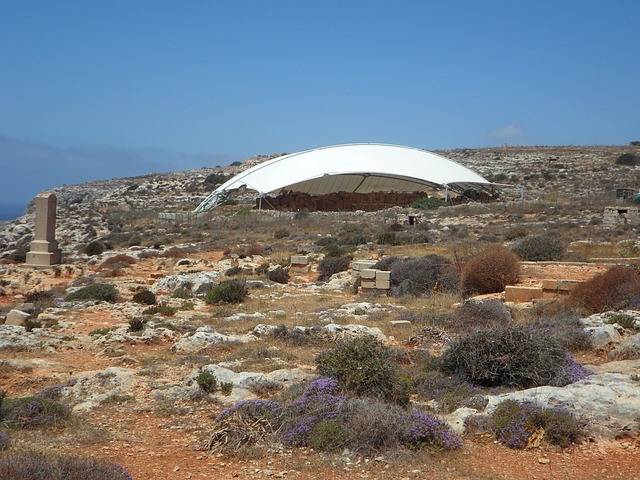Mnajdra temple archaeological site on the coast of Malta with protective canopies