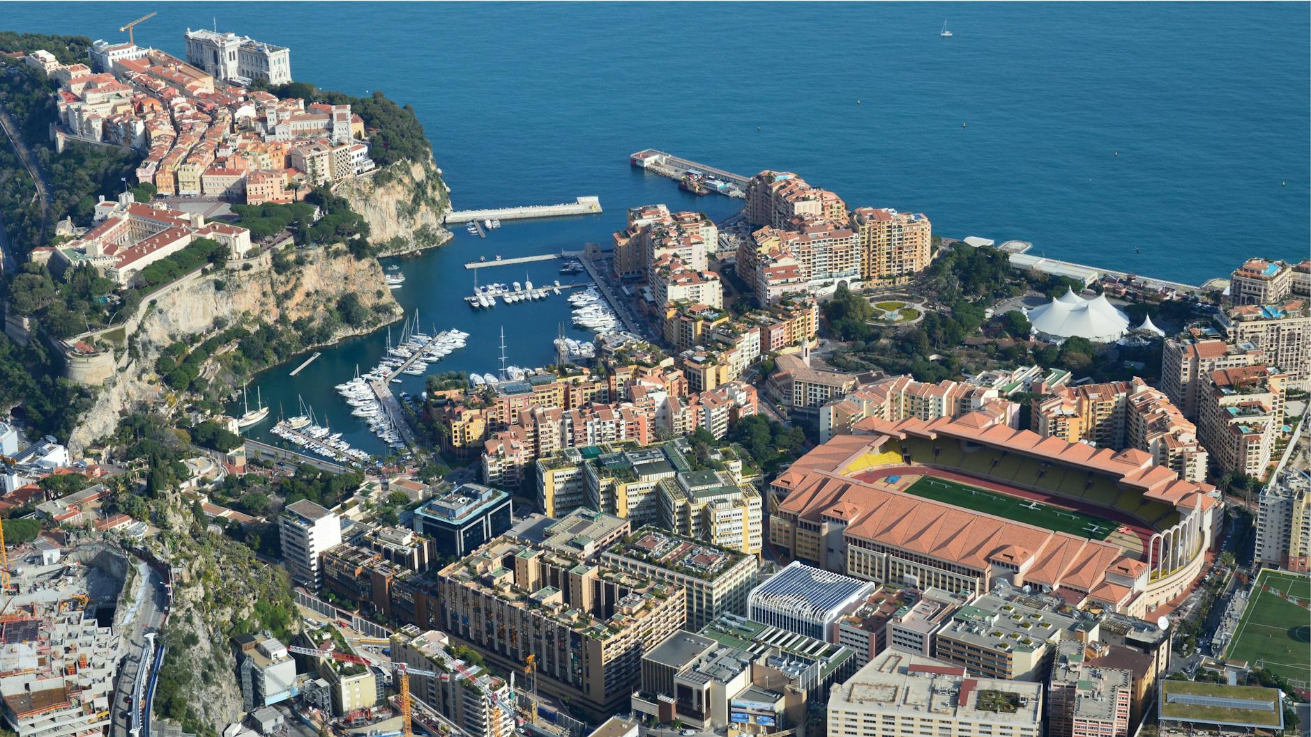 Aerial view of Monaco's coastal cityscape with harbors and Mediterranean Sea