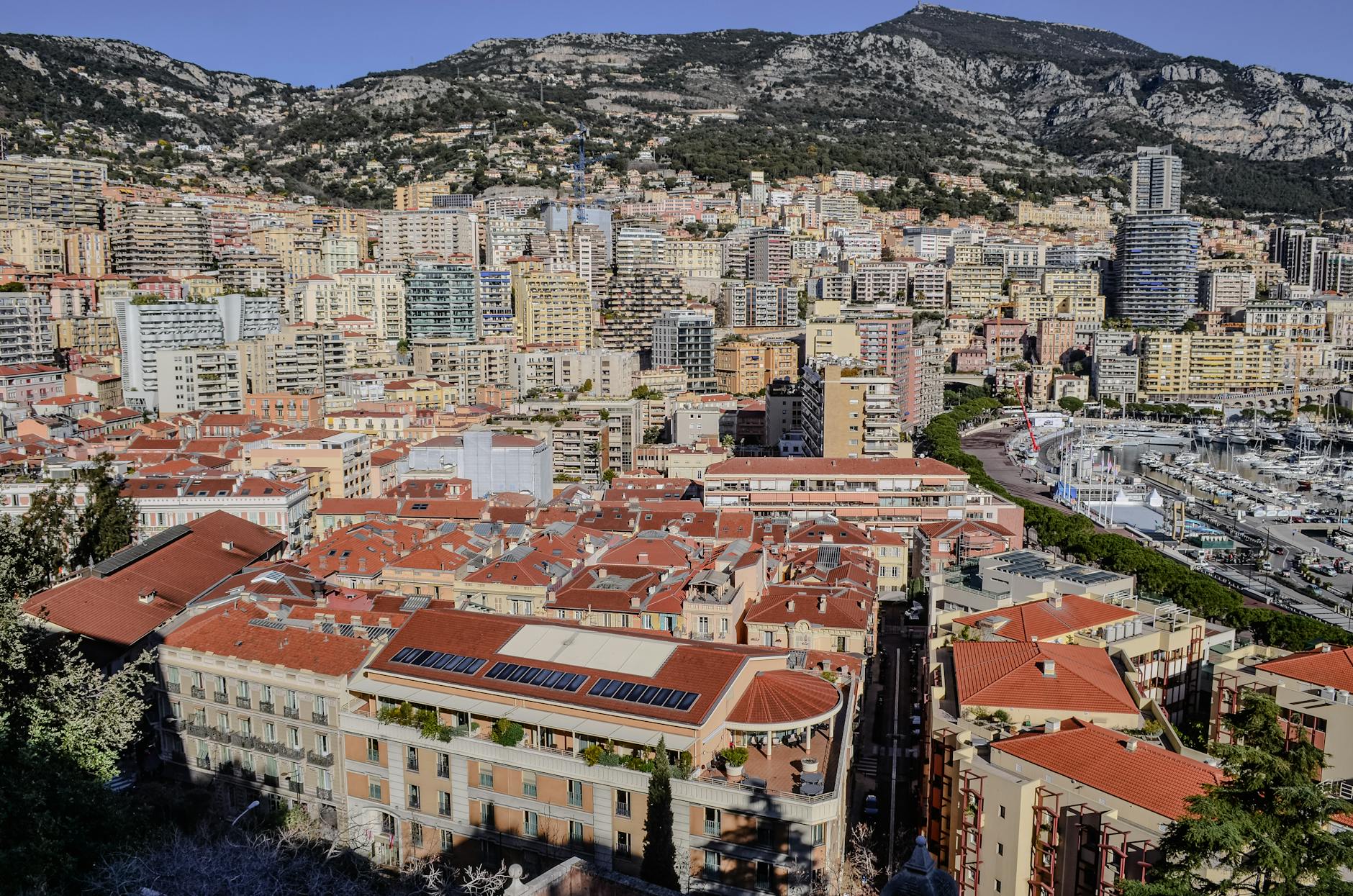 Aerial view of Monaco with red rooftops and the surrounding mountains