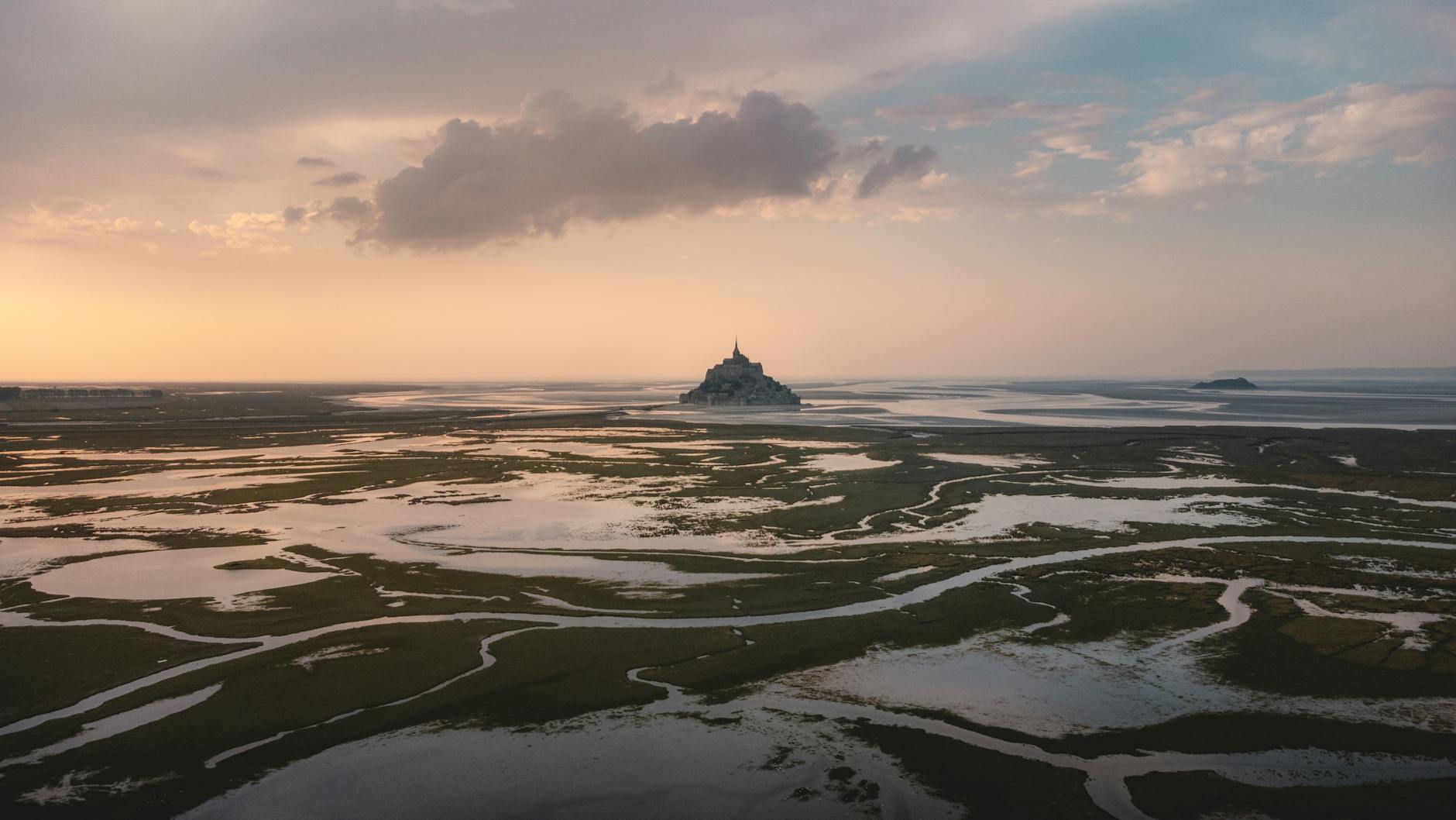 Aerial view of Mont Saint-Michel at sunset during low tide