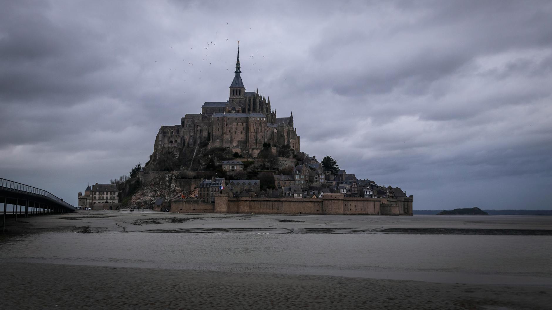 Mont Saint-Michel under dramatic storm clouds in Normandy