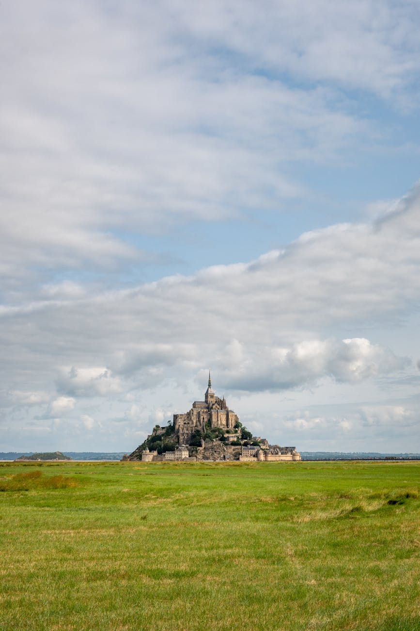 Scenic view of Mont Saint-Michel under partly cloudy sky
