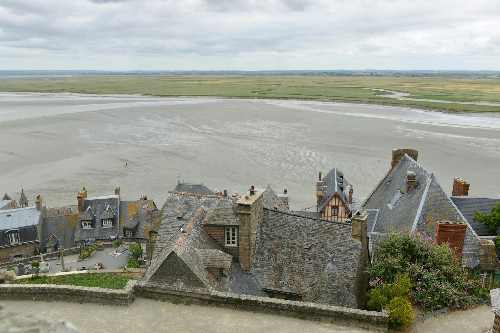 Aerial view of Mont Saint-Michel's historic rooftops overlooking the bay